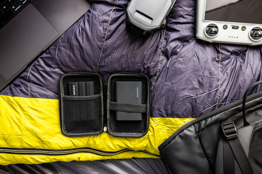 Camping gear including drone and power bank laid out.